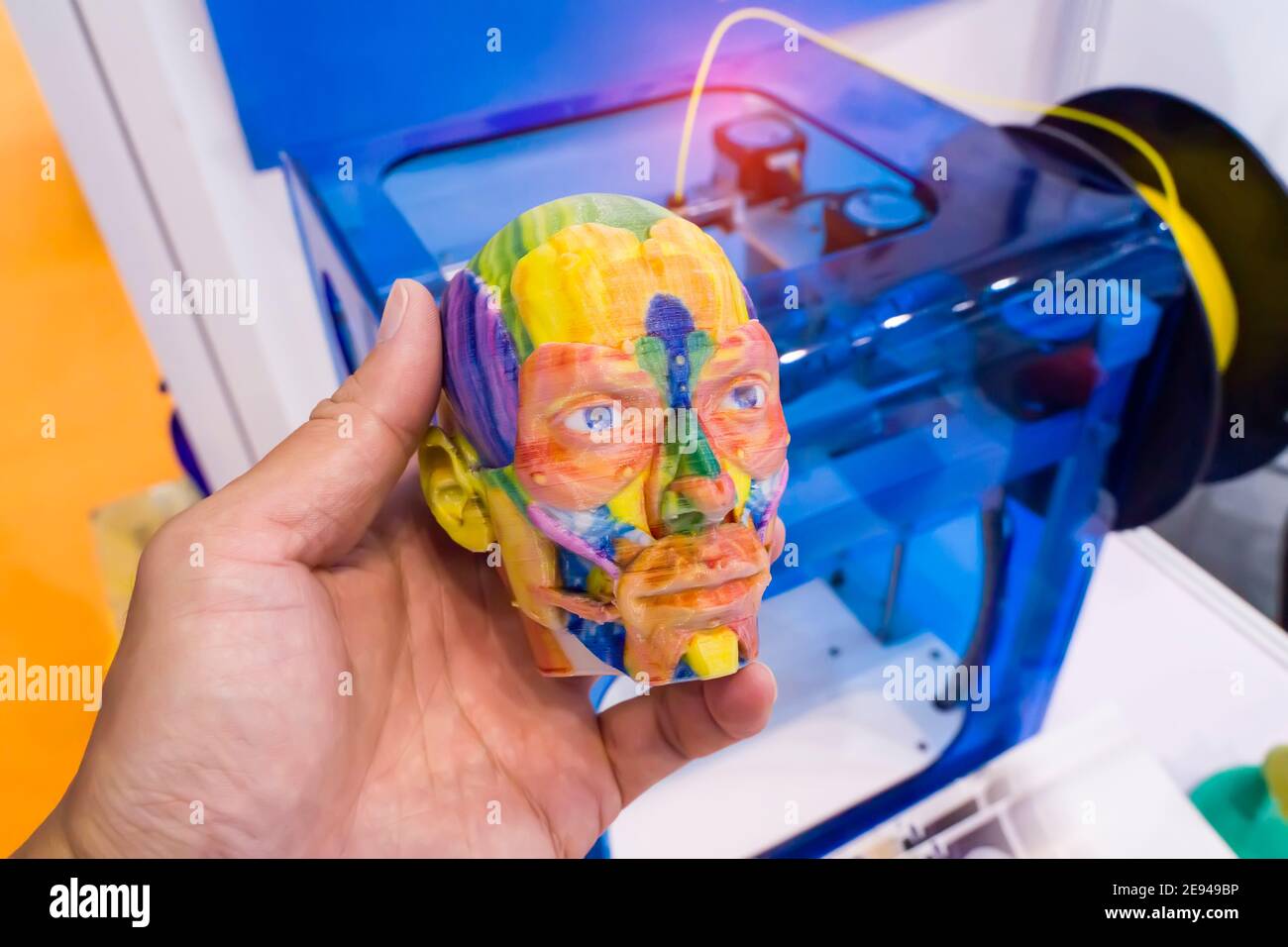 Modell gedruckt auf 3d-Drucker in Form von bunten Muskeln Des Gesichts mit menschlicher Hand, additiven Technologien und futuristischem Konzept Stockfoto