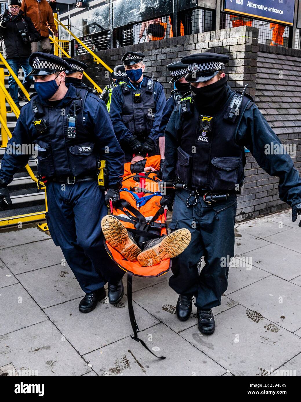 London, Großbritannien. Februar 2021. Demonstranten werden schließlich in speziellen Bahren heruntergebracht und verhaftet - Supporters from Extinction Rebellion inszenieren einen Protest auf dem Vordach über dem Eingang zur 0ne Everrsholt Street. Die londoner Zentrale von HS2- Sie haben ein Banner, das sagt, wesentliche Arbeit sollte heilen nicht schaden. Das Anti-HS2-Lager für die Extinktion wird weiterhin von Gerichtsvollzieher (vom National Enforcement Team, NET, einer Tochtergesellschaft der High Court Enforcement Group) auf der Euston Station geräumt (um einen temporären Parkplatz zu schaffen). Kredit: Guy Bell/Alamy Live Nachrichten Stockfoto