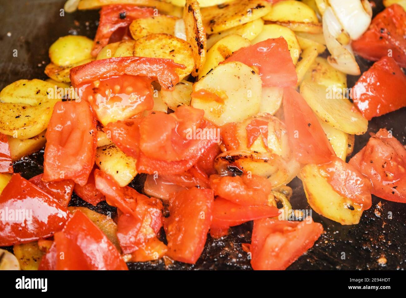 Kartoffeln und Tomaten in kleine Stücke auf elektrischen Grill, Nahaufnahme Detail gegrillt Stockfoto