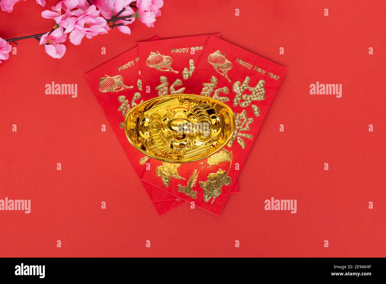 Sakura Blossom, rote Umschläge und goldene Ingot auf rotem Hintergrund Stockfoto