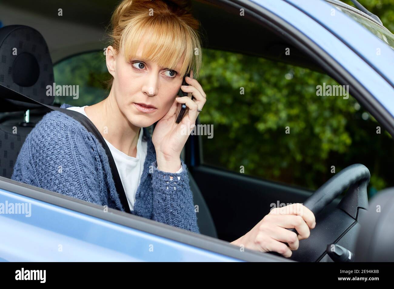 Frau, die zwar mit Handy Stockfoto