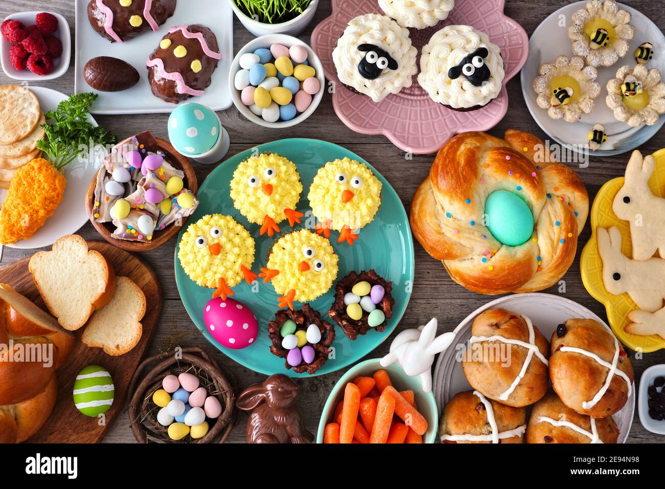 Ostertisch-Szene mit einer Auswahl an Broten, Desserts und Leckereien. Draufsicht über einen Holzhintergrund. Frühlingsurlaub Essen Konzept. Stockfoto