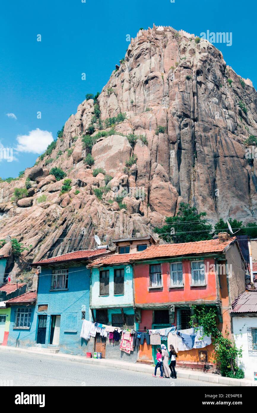 Afyon, auch bekannt als Afyon Kara Hisar oder Afyonkarahisar, Provinz Afyon, Türkei. Typische Häuser unter der Klippe, die über 200 Meter hoch ist und ha Stockfoto