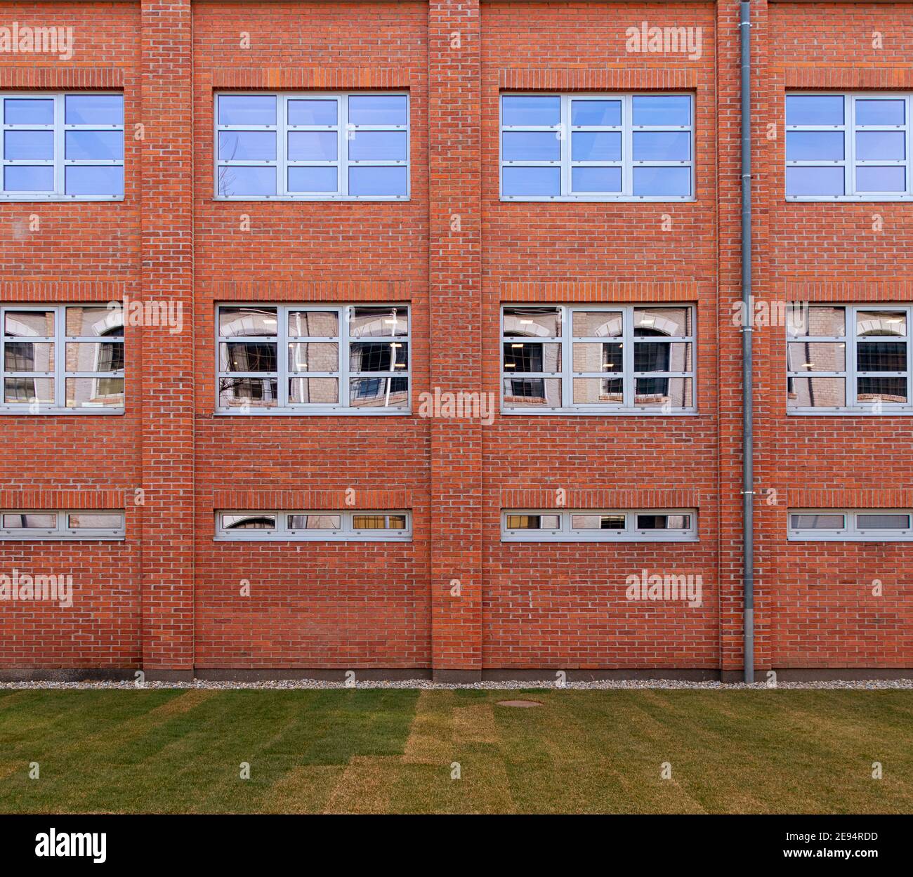 Moderne rote Ziegelfassade mit Fenstern Stockfoto