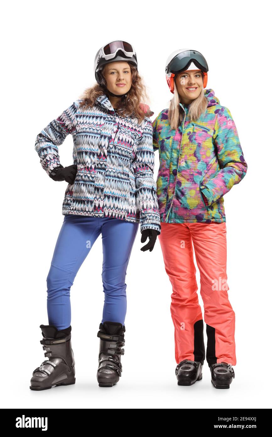 Ganzkörperportrait einer zwei Freundinnen im Ski Uniformen lächeln und betrachten die Kamera isoliert auf einem Weißer Hintergrund Stockfoto