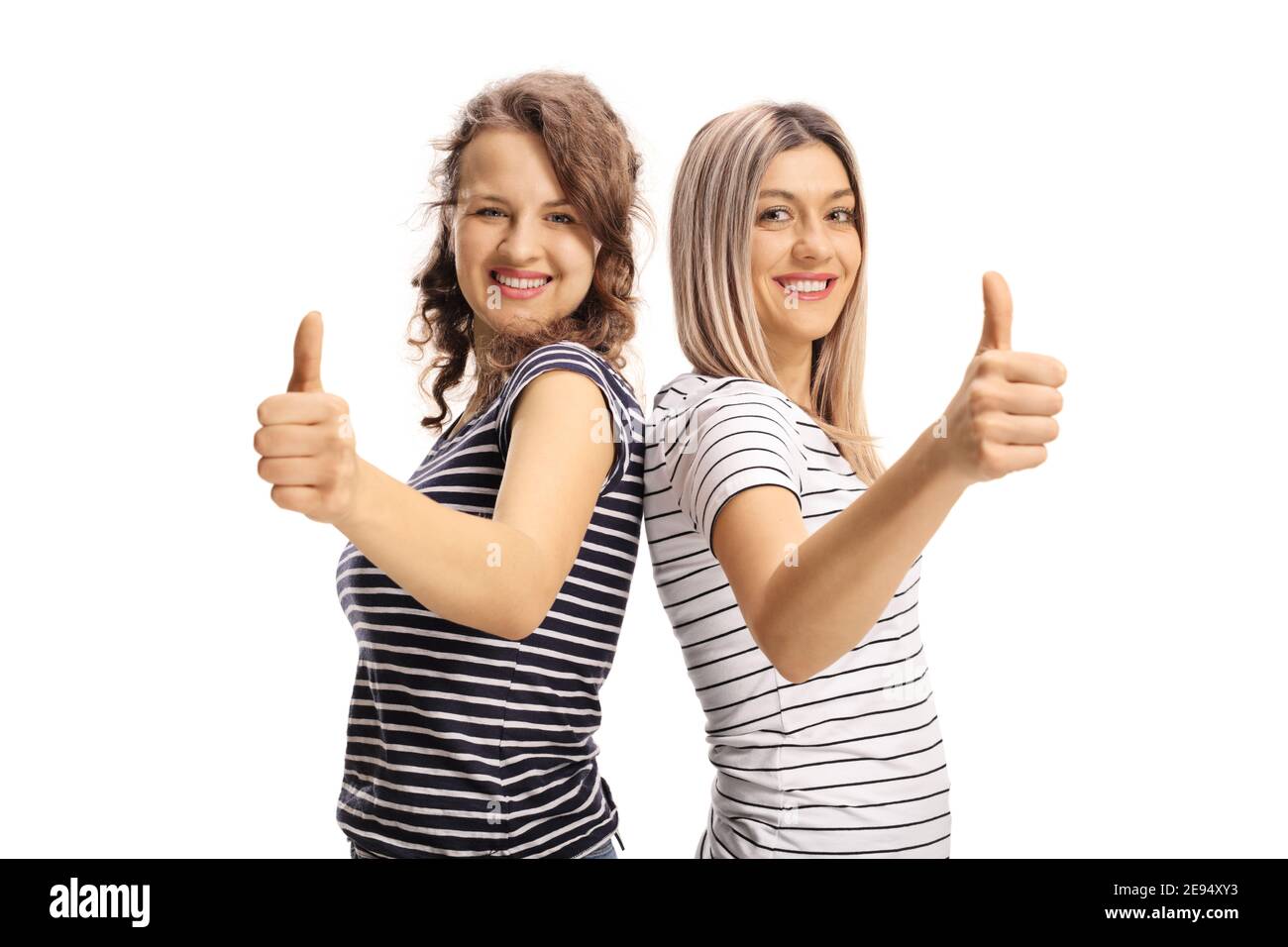 Zwei fröhliche junge Frauen zeigen Daumen nach oben isoliert auf weiß Hintergrund Stockfoto
