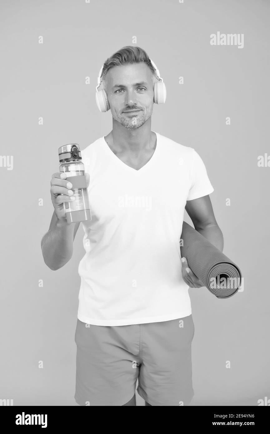 Muskulösen Mann trainieren zu Hause mit Sportmatte, Turnhalle Playlist Konzept. Stockfoto