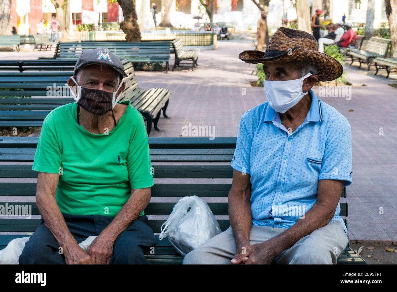 Zwei ältere Männer tragen Gesichtsschutzmasken im Leoncio Vidal Park. Es ist die Zeit der Covid-19-Pandemie. Santa Clara, Kuba Stockfoto