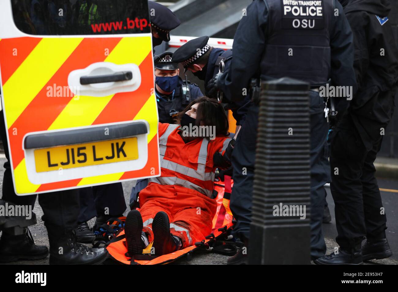 Ein Protestierender der Ausrottungsaufstand wird von Polizisten festgenommen, nachdem er vom Vordach des HS2-Büros in der Eversholt Street in London heruntergehoben wurde, wo die Demonstranten ein Banner aufgehängt hatten. Bilddatum: Dienstag, 2. Februar 2021. Stockfoto