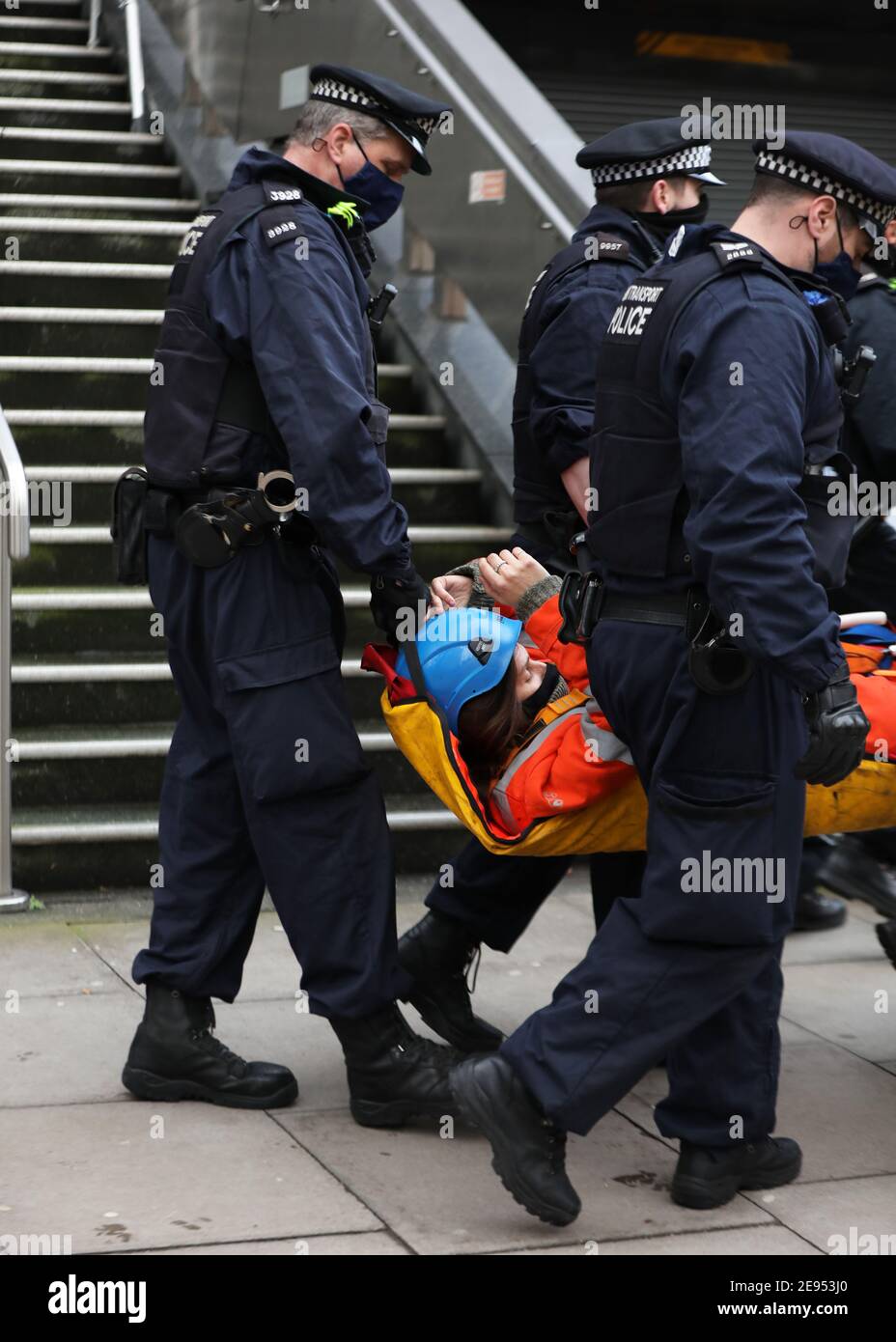 Ein Protestierender der Ausrottungsaufstand wird von Polizisten festgenommen, nachdem er vom Vordach des HS2-Büros in der Eversholt Street in London heruntergehoben wurde, wo die Demonstranten ein Banner aufgehängt hatten. Bilddatum: Dienstag, 2. Februar 2021. Stockfoto