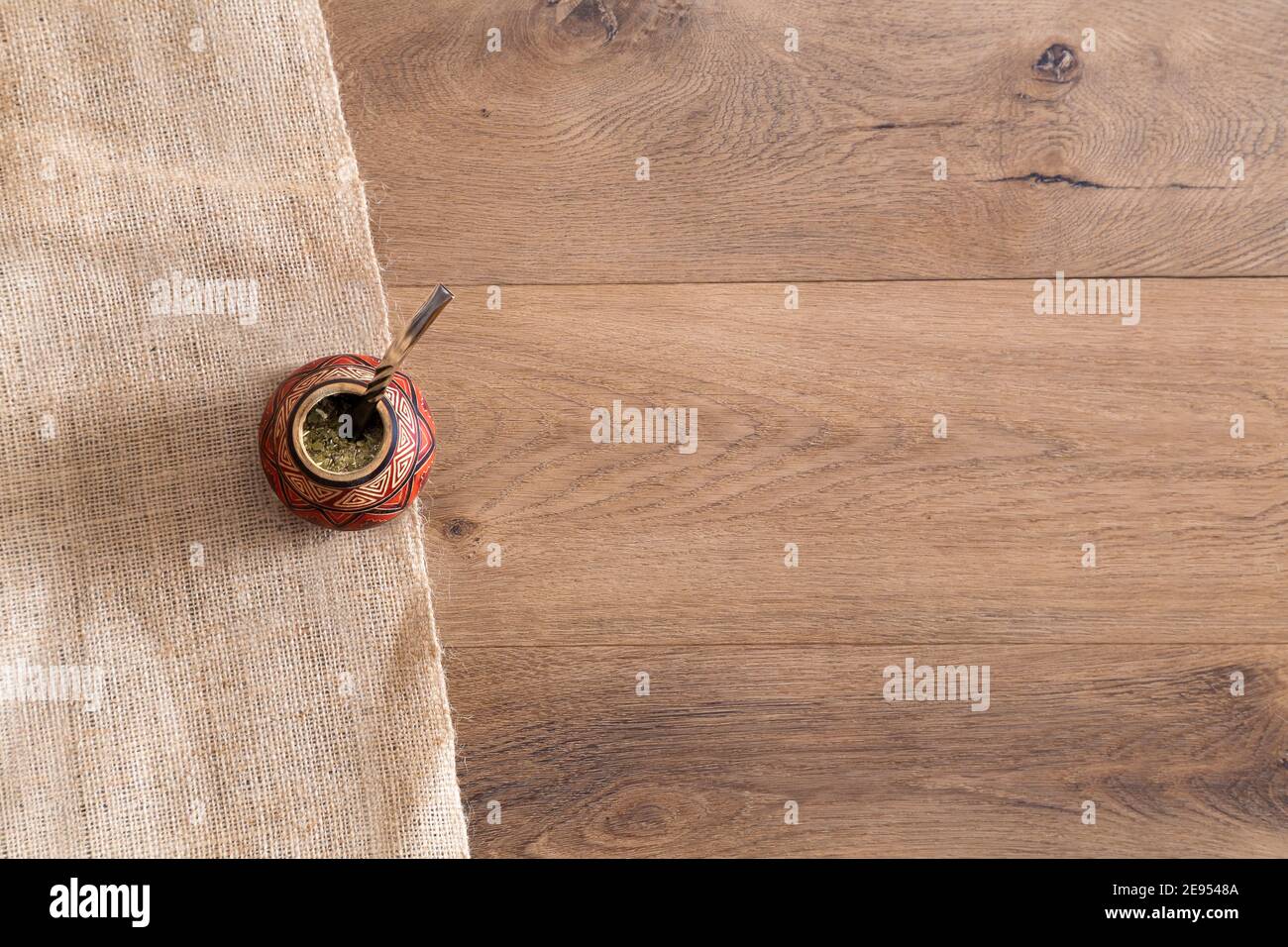 Draufsicht auf einen Kumpel aus Kalabash über einem Holztisch. Traditionelles heißes Getränk aus Südamerika. Yerba Mate. Speicherplatz kopieren. Stockfoto