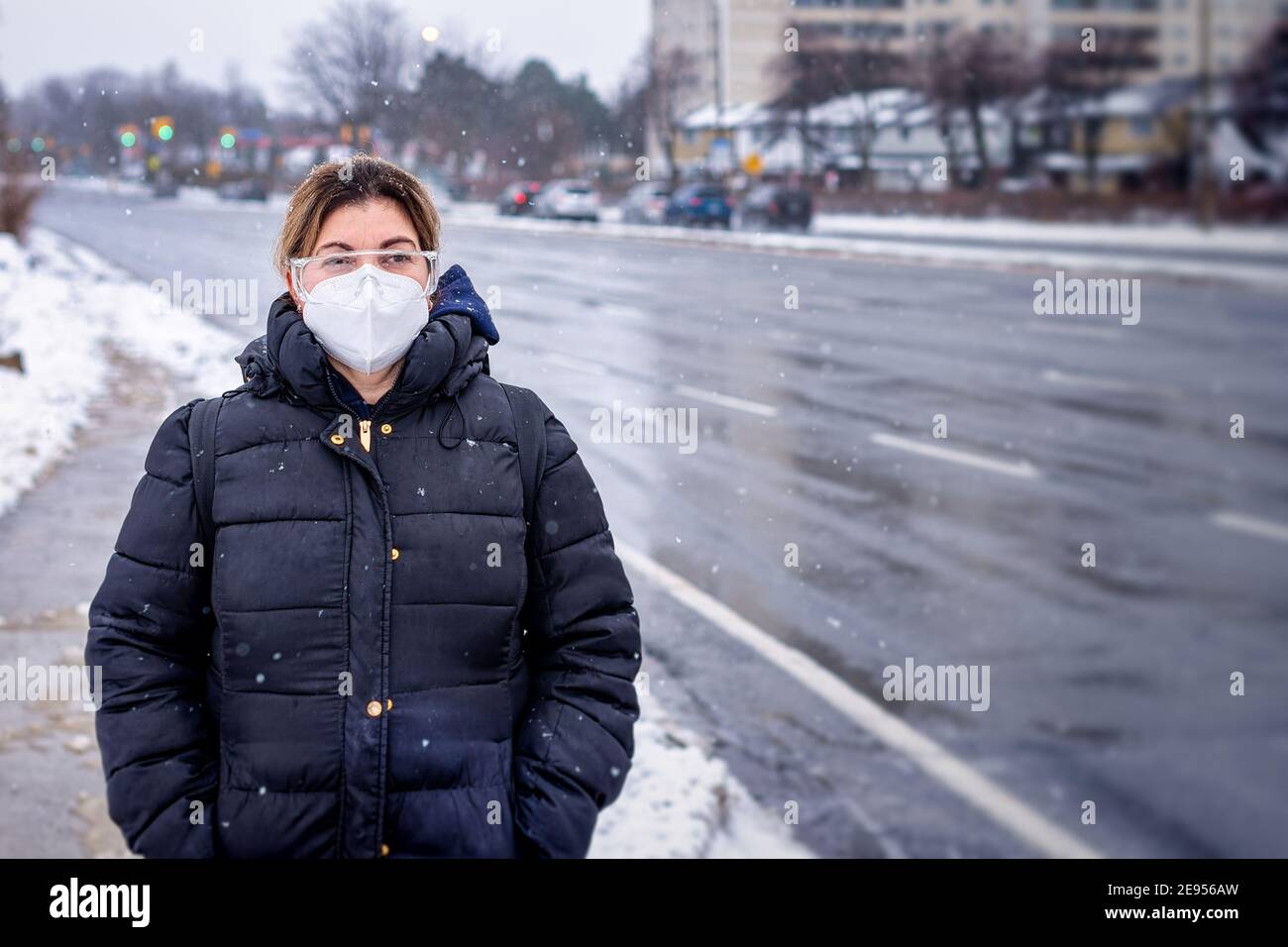 Covid-19 oder Coronavirus, eine Frau mit einer schützenden Gesichtsmaske im Winter, Kanada, 2021 Stockfoto