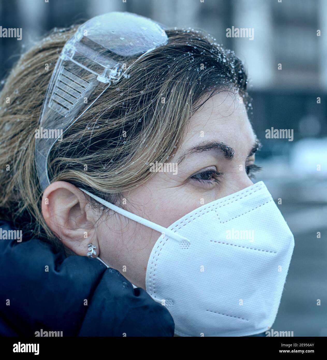 Covid-19 oder Coronavirus, eine Frau mit einer schützenden Gesichtsmaske im Winter, Kanada, 2021 Stockfoto