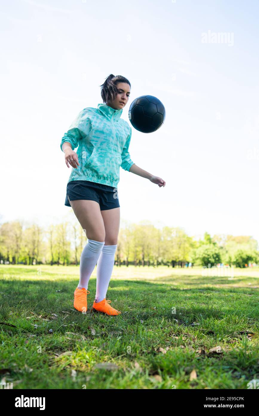 Porträt einer jungen Frau, die Fußball übt und Tricks mit dem Fußball macht. Fußballspieler jongliert mit dem Ball. Sportkonzept. Stockfoto