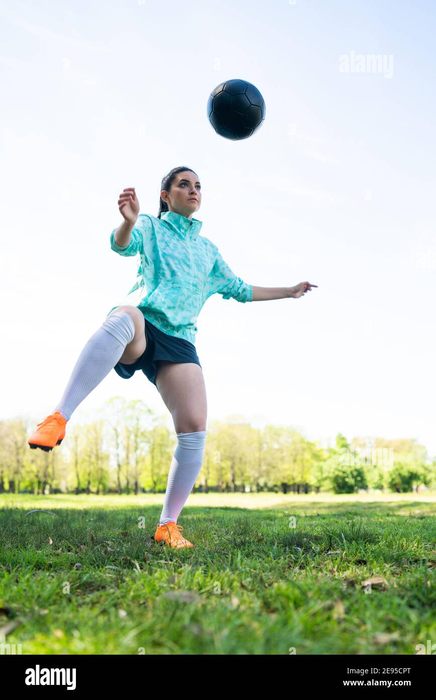 Porträt einer jungen Frau, die Fußball übt und Tricks mit dem Fußball macht. Fußballspieler jongliert mit dem Ball. Sportkonzept. Stockfoto