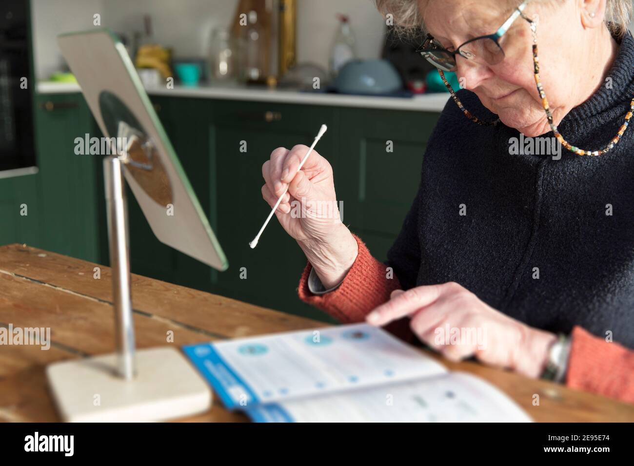 Eine ältere Frau prüft die Anweisungen für einen Heimtest Überprüfung des Coronavirus-Abstrichs Stockfoto