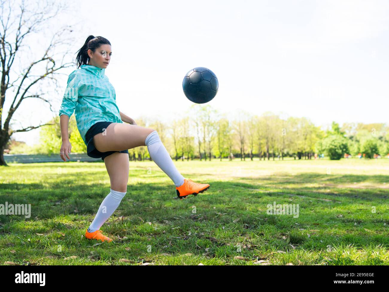 Porträt einer jungen Frau, die Fußball übt und Tricks mit dem Fußball macht. Fußballspieler jongliert mit dem Ball. Sportkonzept. Stockfoto