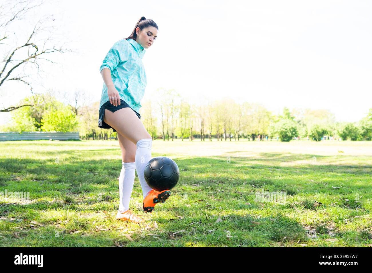 Porträt einer jungen Frau, die Fußball übt und Tricks mit dem Fußball macht. Fußballspieler jongliert mit dem Ball. Sportkonzept. Stockfoto