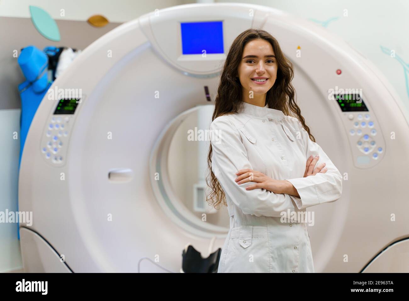 Die junge Ärztin im medizinischen Gewand schaut in die Kamera. Patient nach Computertomographie. CT-Diagnostik in der medizinischen Klinik Stockfoto