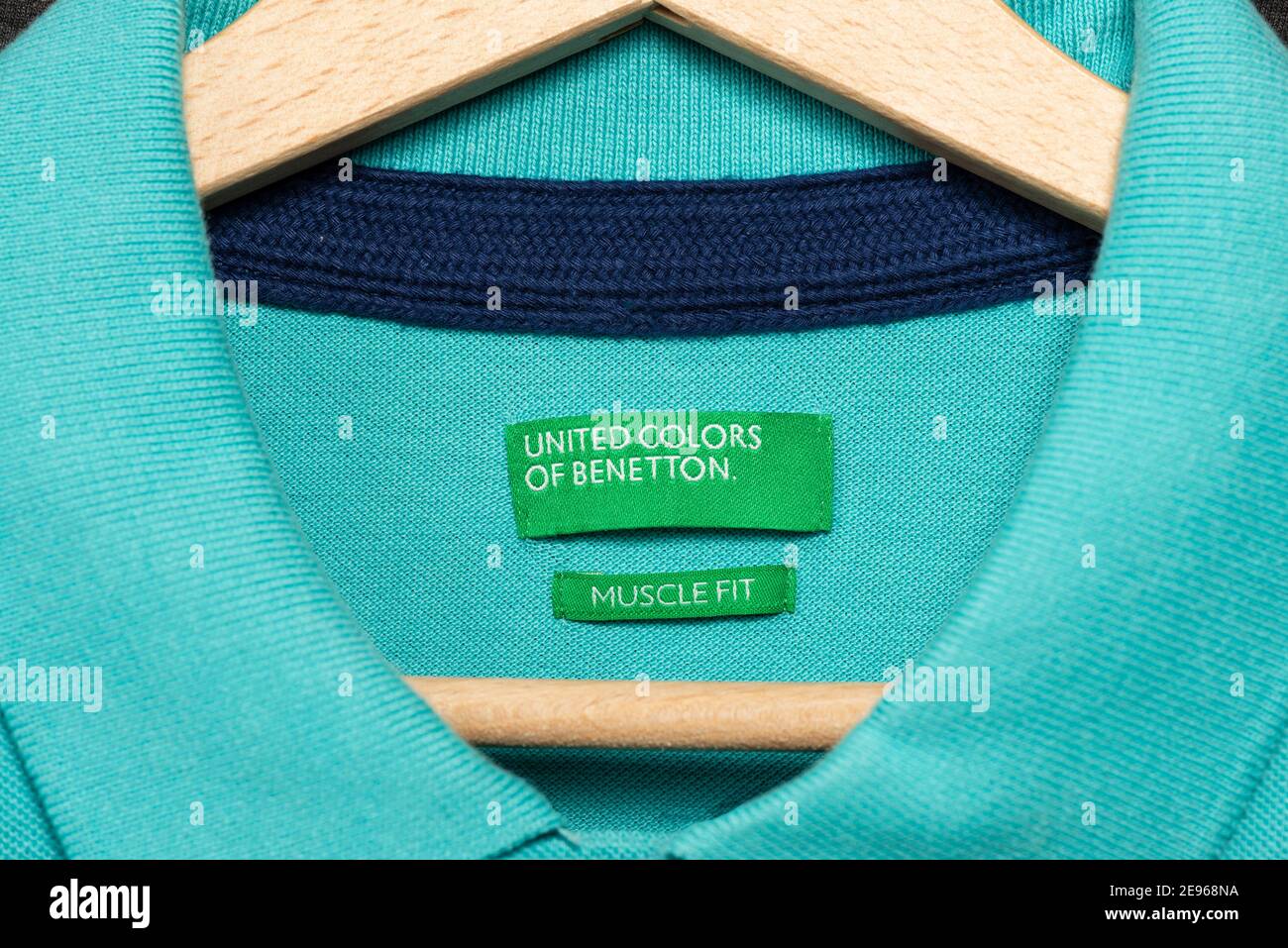 Vereinigte Farben von Benetton Muscle Fit grünes Label auf Teal T-Shirt hängen auf Holz Kleiderbügel. Stockfoto