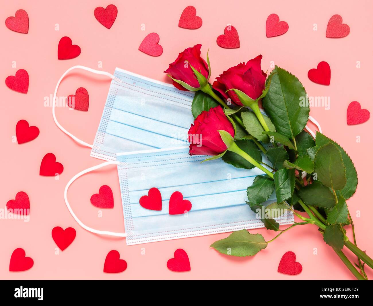 Rote Rosen und medizinische Einweg-Gesichtsmaske mit vielen roten Herzen  auf rosa Hintergrund. Mütter, Frauen oder Valentinstag Feier in Coronavirus  pande Stockfotografie - Alamy