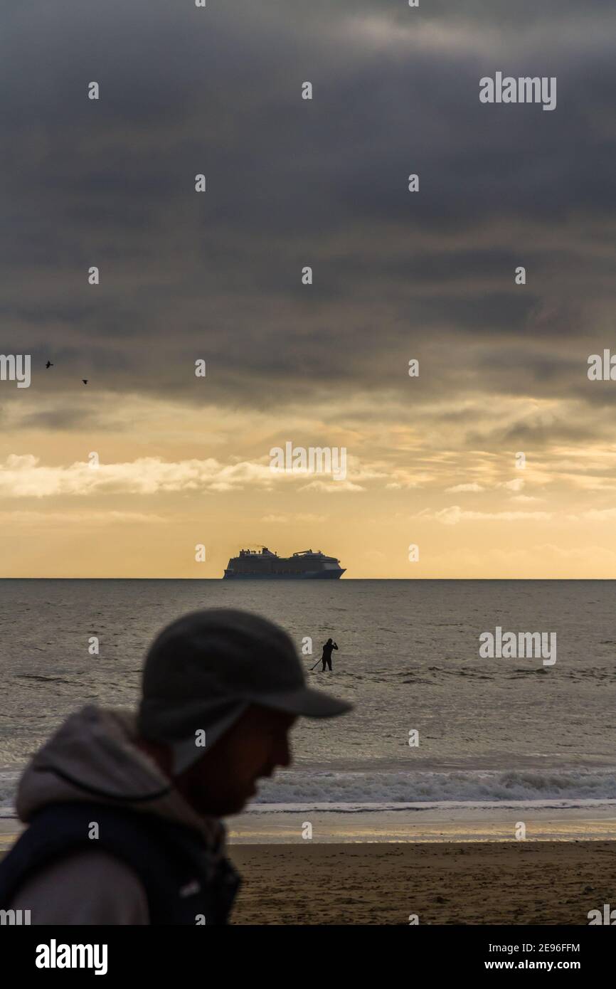 BOURNEMOUTH, ENGLAND - JANUAR 17 2021: Kreuzfahrtschiff vor Bournemouth in der Poole Bay, Silhouette des Walkerkopfes, Porträt, Surfer-Paddeln, Kopys Stockfoto