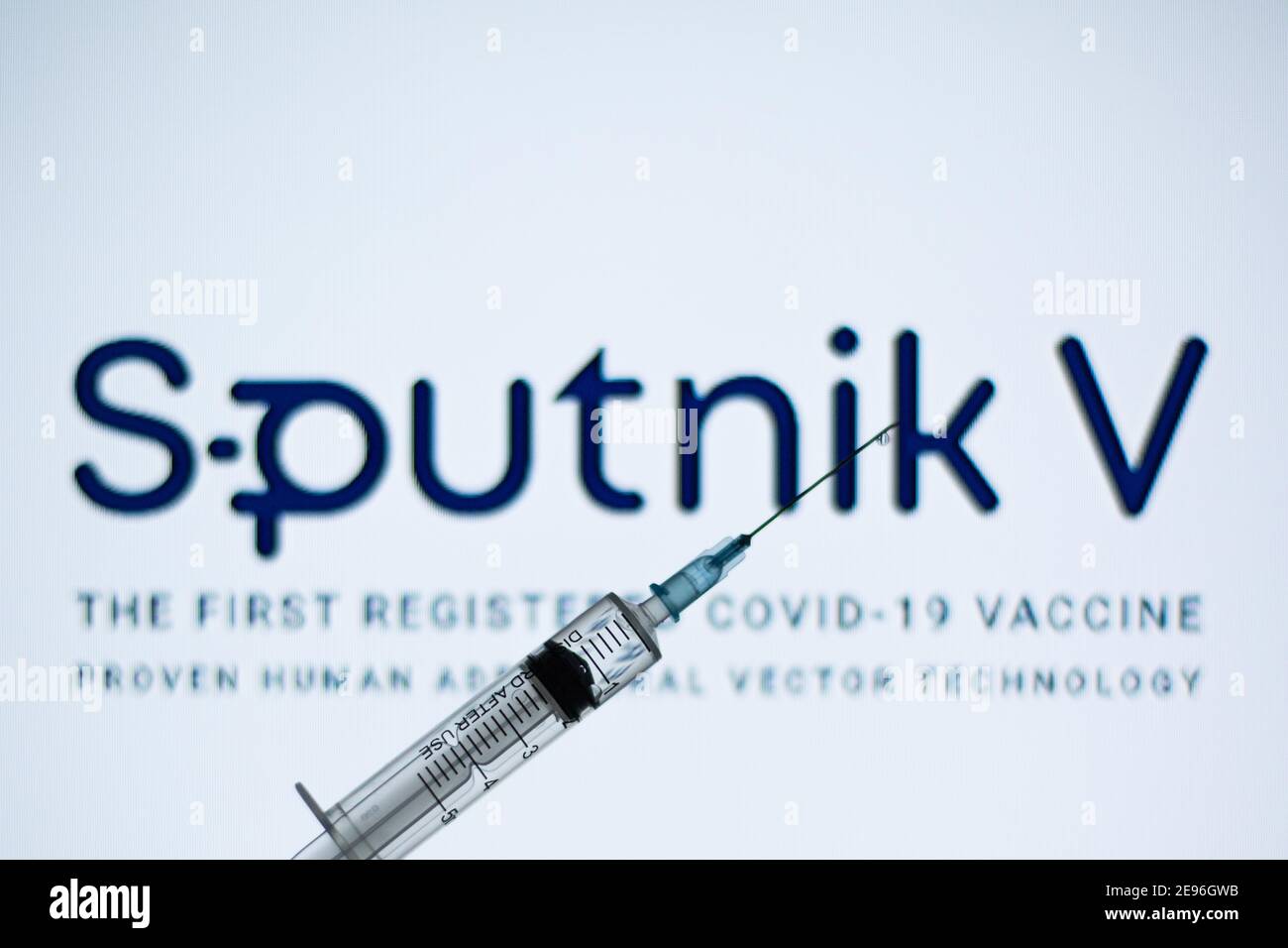 In dieser Abbildung ist eine medizinische Spritze vor dem Sputnik V Logo zu sehen. Stockfoto
