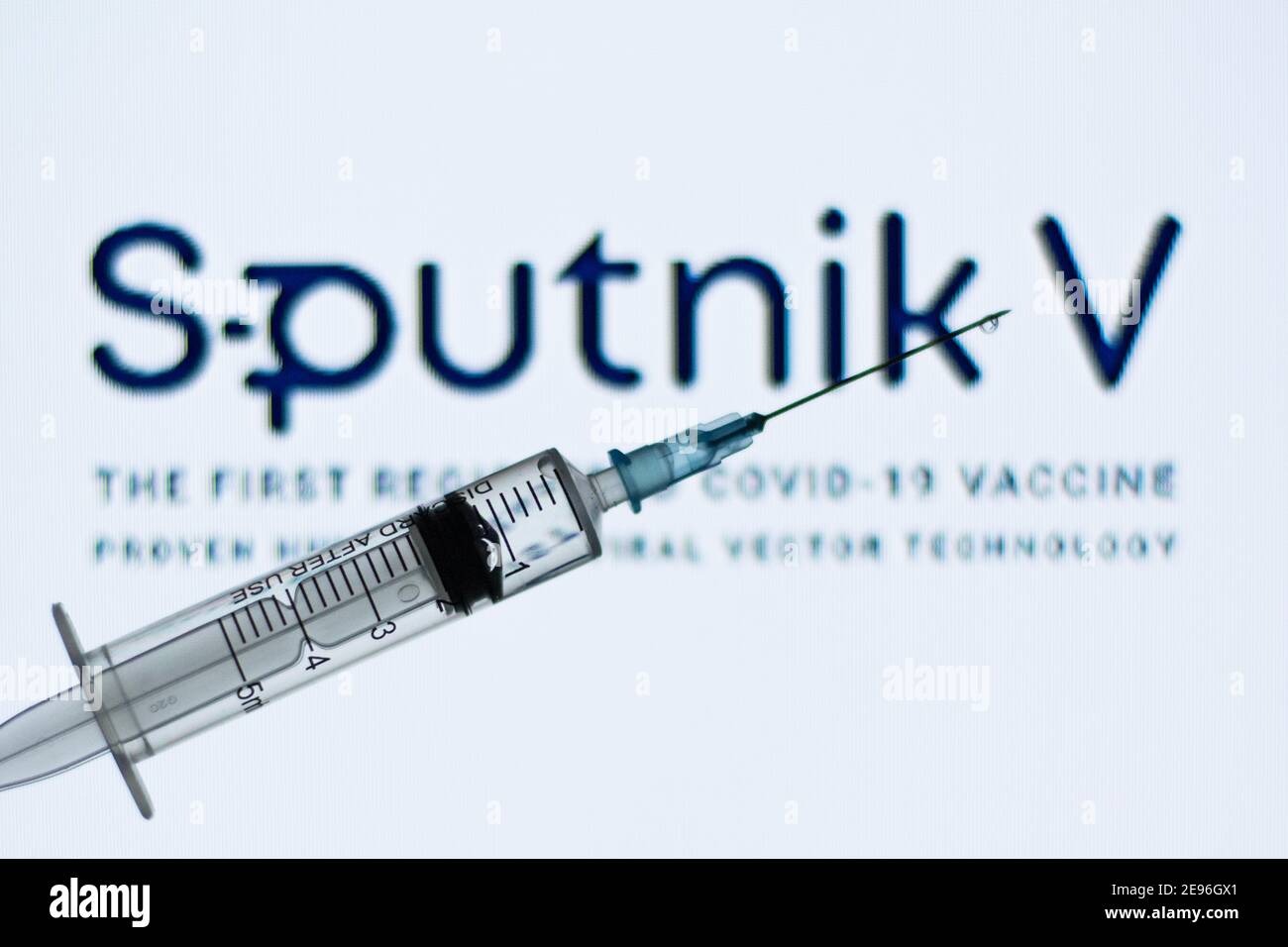 In dieser Abbildung ist eine medizinische Spritze vor dem Sputnik V Logo zu sehen. Stockfoto