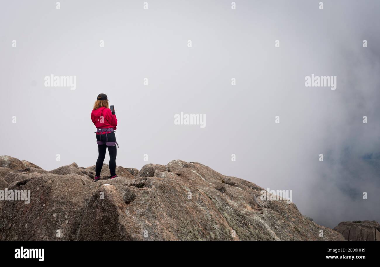 Frau auf dem Gipfel des Berges auf einem nebligen Tag Stockfoto