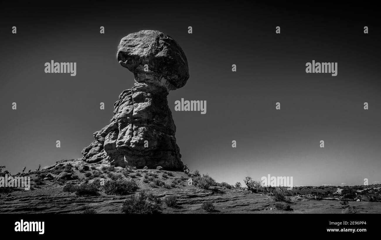 Schwarz-Weiß Foto von Balanced Rock, einem hohen und zarten Sandstein Felsformation in der Wüstenlandschaft des Arches National Park, Moab, Utah, USA Stockfoto