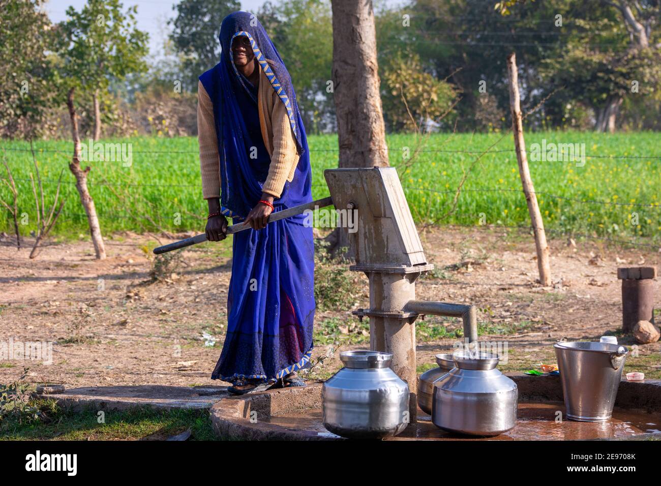 TIKAMGARH, MADHYA PRADESH, INDIEN - 23. JANUAR 2021: Unbekannte Inderin, die Handpumpe für Trinkwasser verwendet. Stockfoto