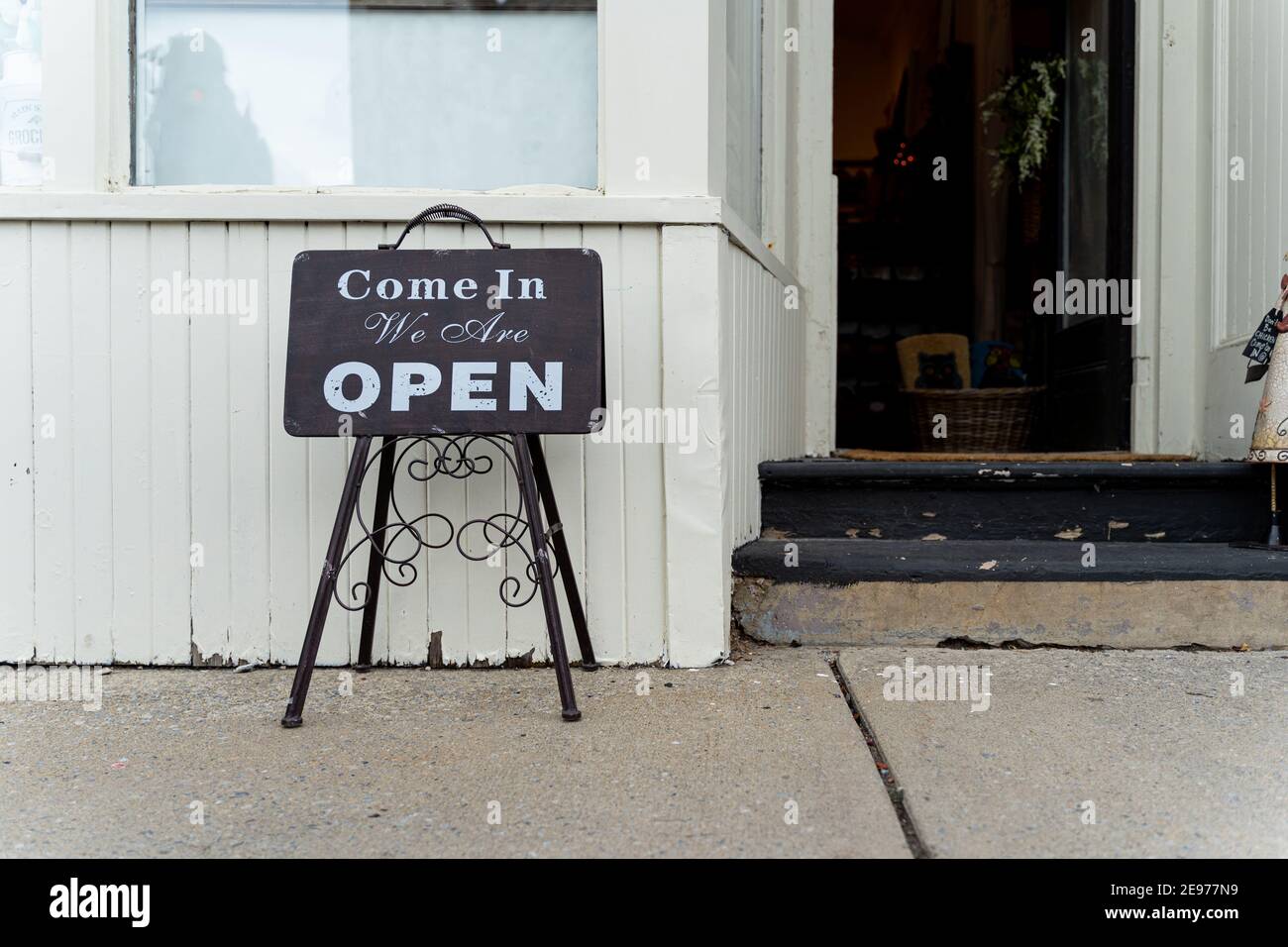 Einzelhandel und Einkaufen Bild von einem offenen Schild in einem Geschäft Vorderseite. Sign read Kommen Sie herein wir sind offen. Stockfoto