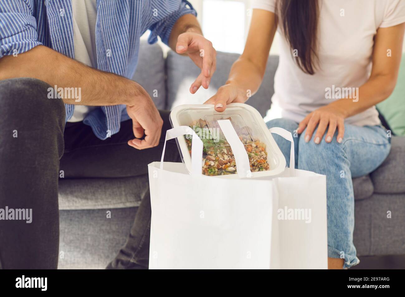 Hände von Mann und Frau, die gesunde Lebensmittel verpackt geliefert Bestellung aus Papiertüte Stockfoto