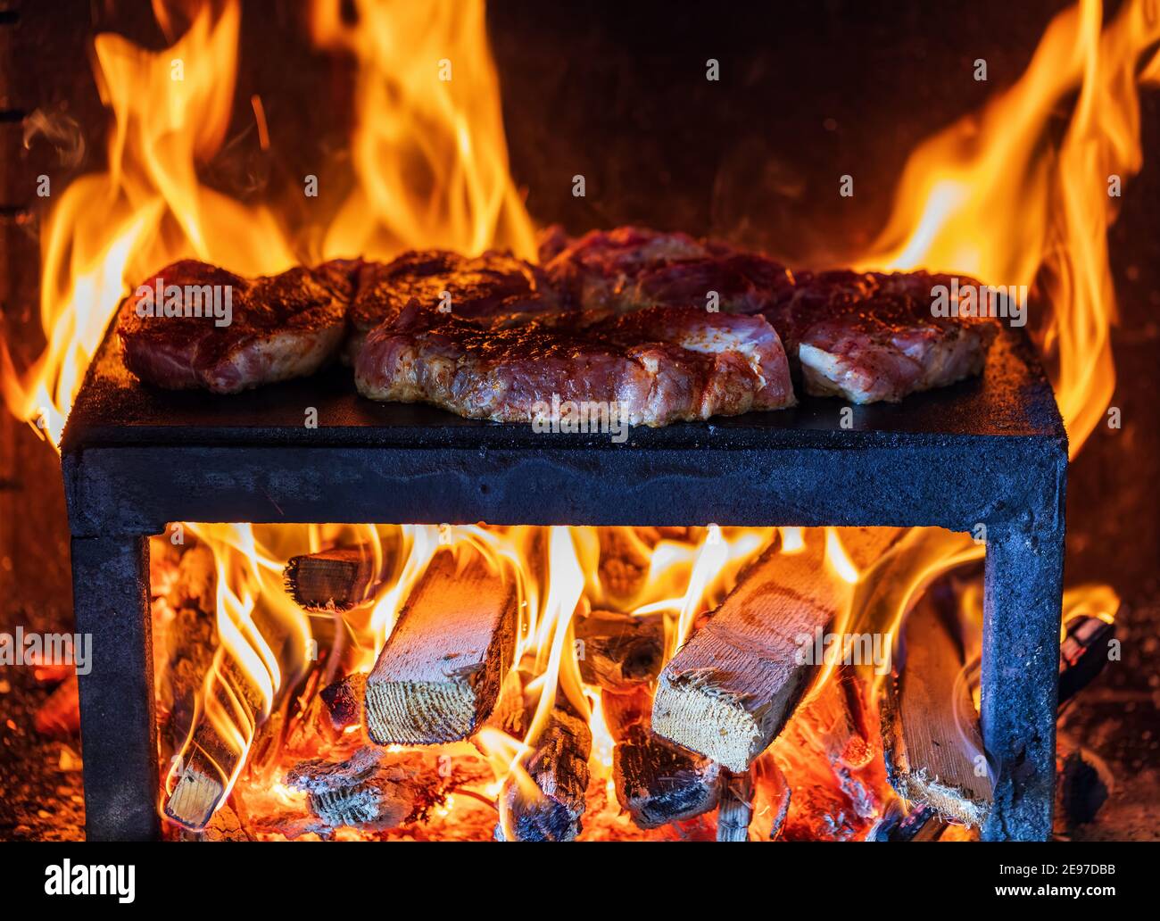 Schweinefleisch Steaks Vorbereitung auf die auf einem Garten Steinplatte Grill Stockfoto
