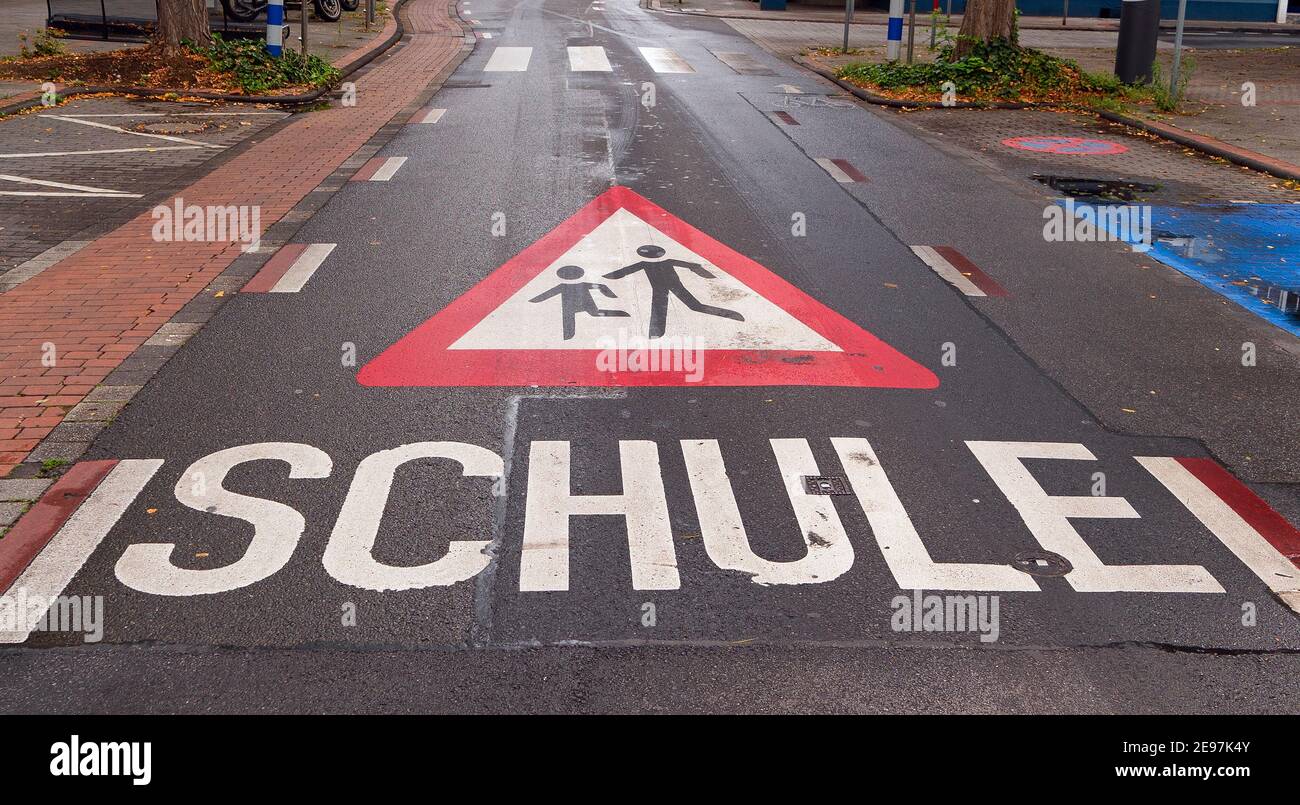 Warnschild für spielende Kinder auf dem Asphalt gemalt. Schule ist deutsch und bedeutet Schule Stockfoto