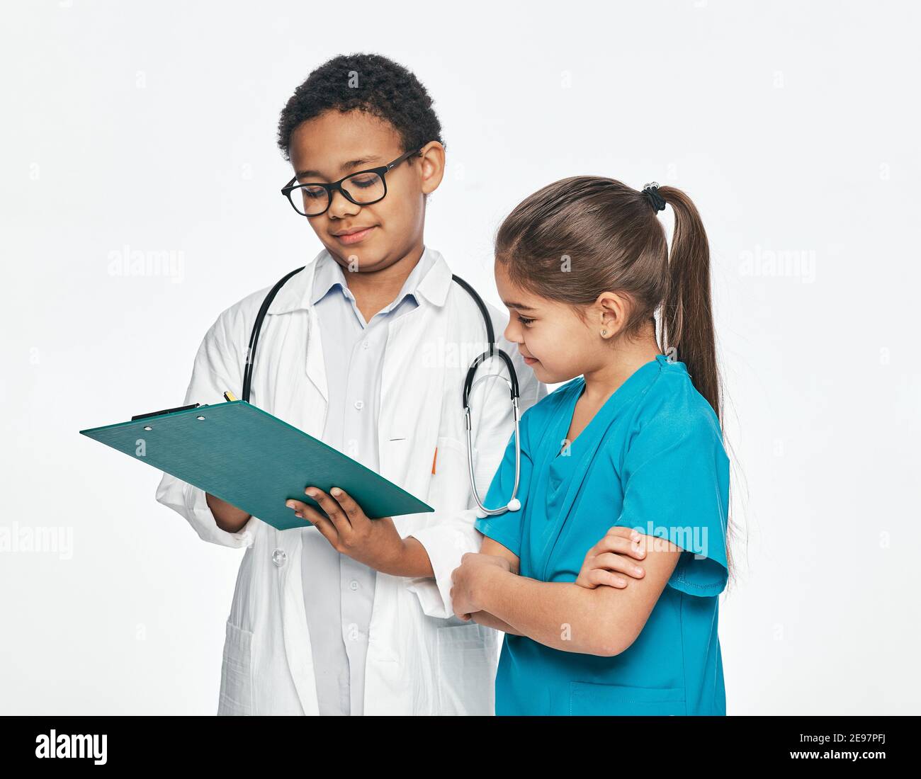 Zwei Kinder spielen medizinisches Personal und wählen einen medizinischen Beruf. Consilium eines Jungen, der Arzt praktiziert, und einer kleinen Krankenschwester Stockfoto