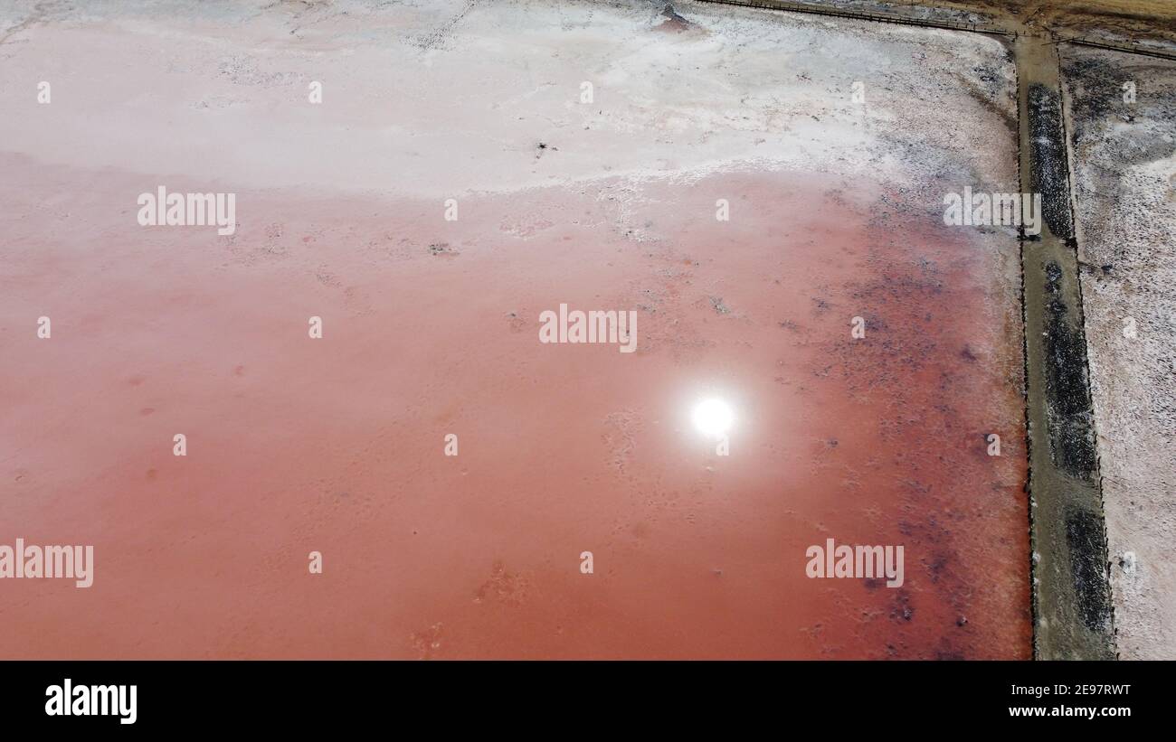 Luftaufnahme von oben auf schönen Salzsee mit rosa Wasser. Blick auf den rosa See von der fliegenden Drohne. Drohne Kopter Fotografie von oben. Landschaft mit Drohne Stockfoto