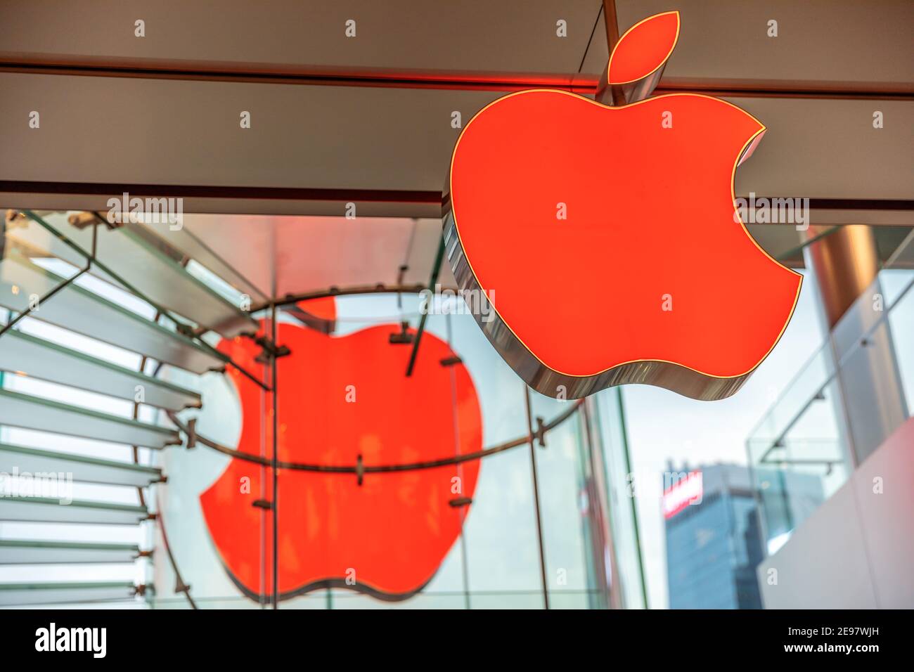Hongkong, China - 4. Dezember 2016: Zwei rote Apple-Logos von Angesicht zu Angesicht im Apple-Laden der IFC Mall, mit einer zentralen Treppe auf diesen drei Ebenen Stockfoto