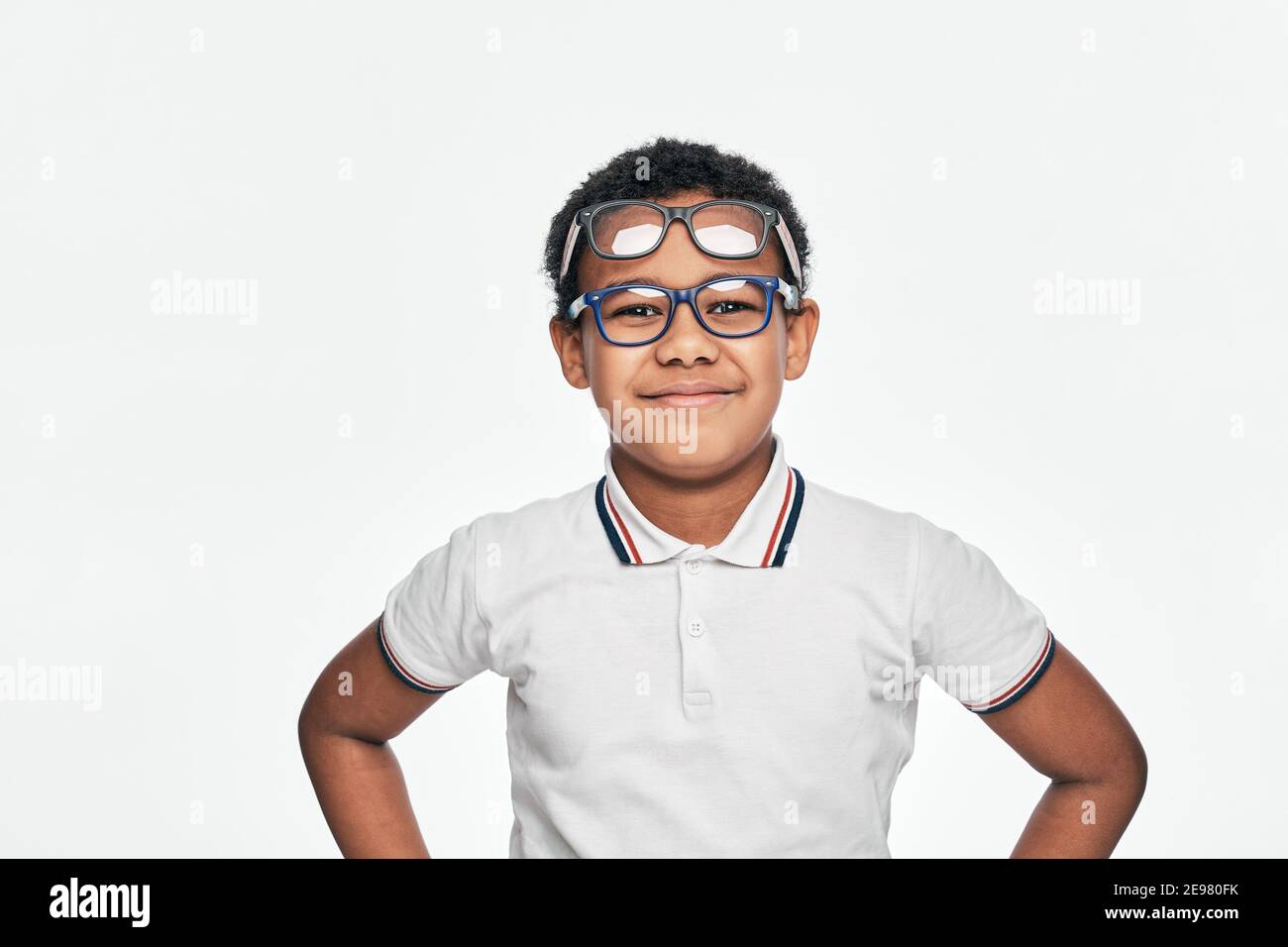 Afroamerikanischer Junge mit positiven Emotionen trägt viele stilvolle Brillen auf weißem Hintergrund. Kinder, Sehkorrektur Stockfoto