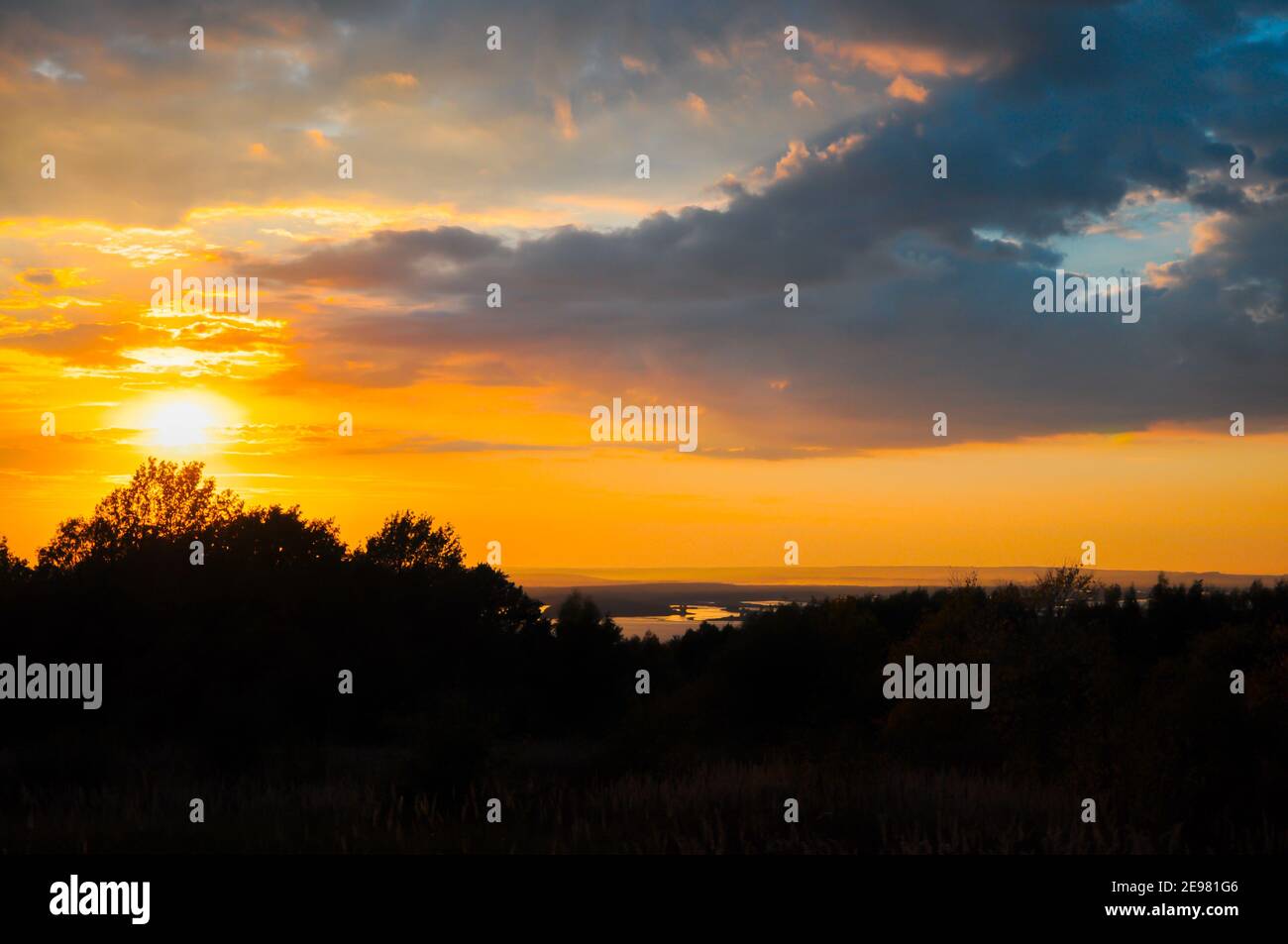 Farbenfrohe Herbstlandschaft bei Sonnenuntergang, Blick auf die sonnenbeschienenen Hügel, den Fluss unten und die neblige Distanz am Horizont Stockfoto