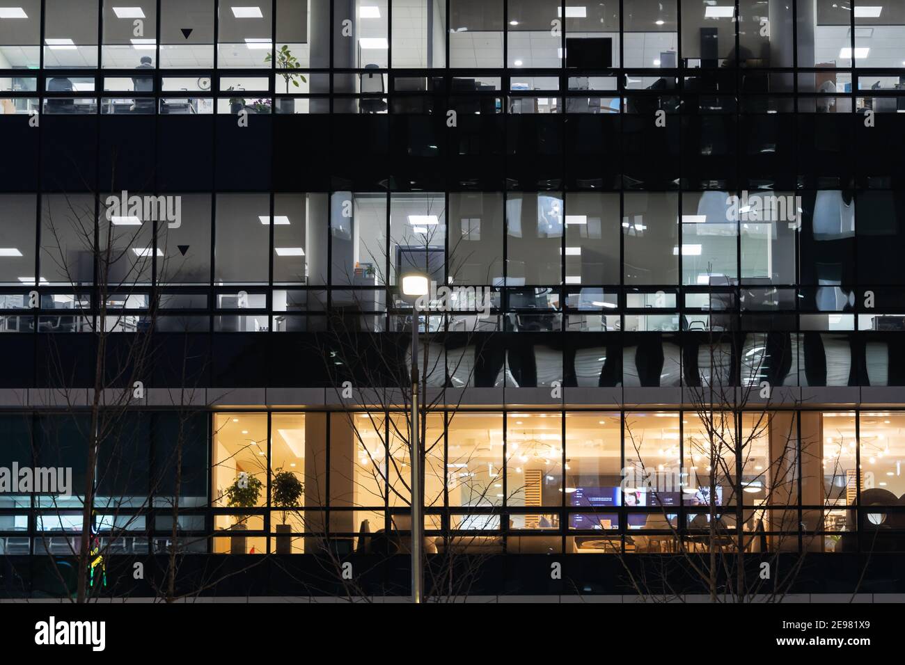 Die Fenster eines modernen Bürogebäudes mit Beleuchtung im Inneren Nachts Stockfoto