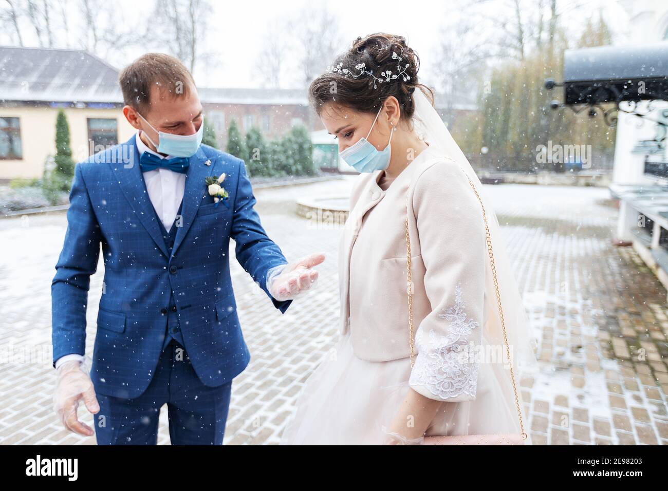 Menschen tragen medizinische Masken zueinander, sorgen für die Gesundheit eines geliebten Menschen während einer Pandemie, Sicherheit und Hygiene in einer Schutzmaske und Handschuhen Stockfoto