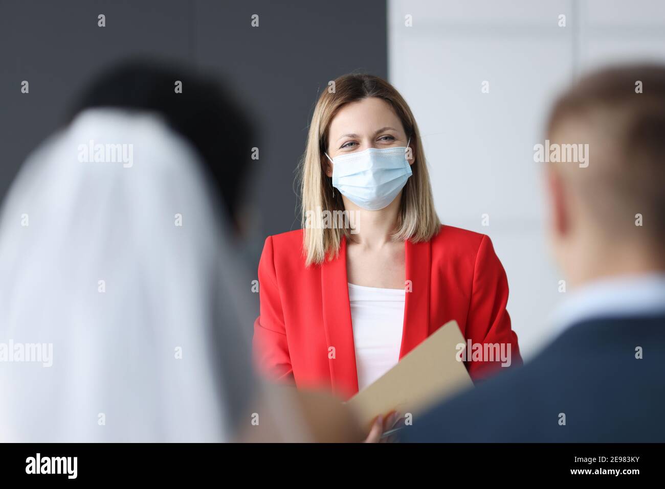 Frau schützende medizinische Maske auf ihrem Gesicht Registrieren Ehe Stockfoto