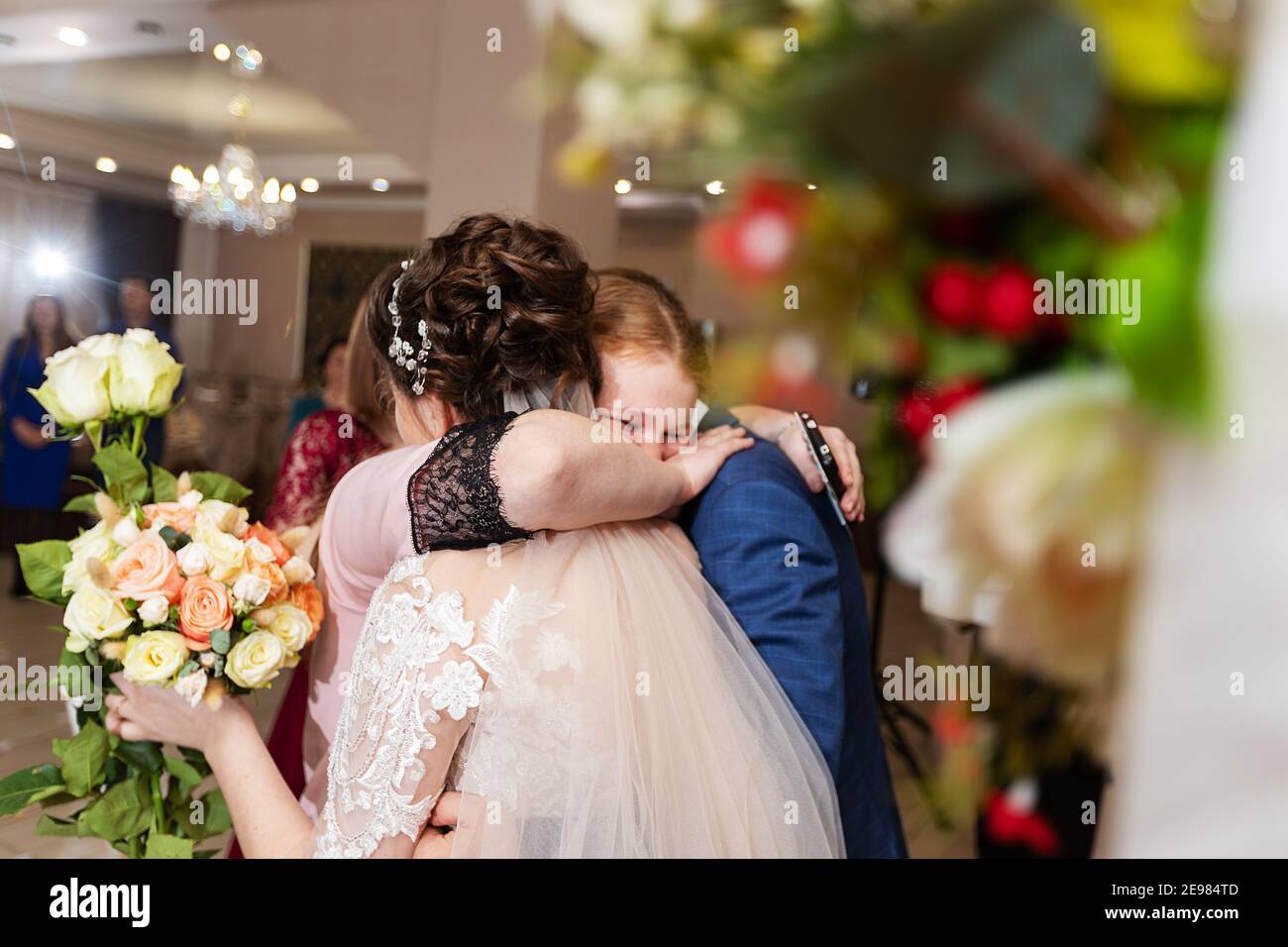 Die Braut und der Bräutigam küssen und tanzen in einem Restaurant, das Glück des Brautpaares bei der Hochzeitszeremonie, ein romantischer Kuss Stockfoto