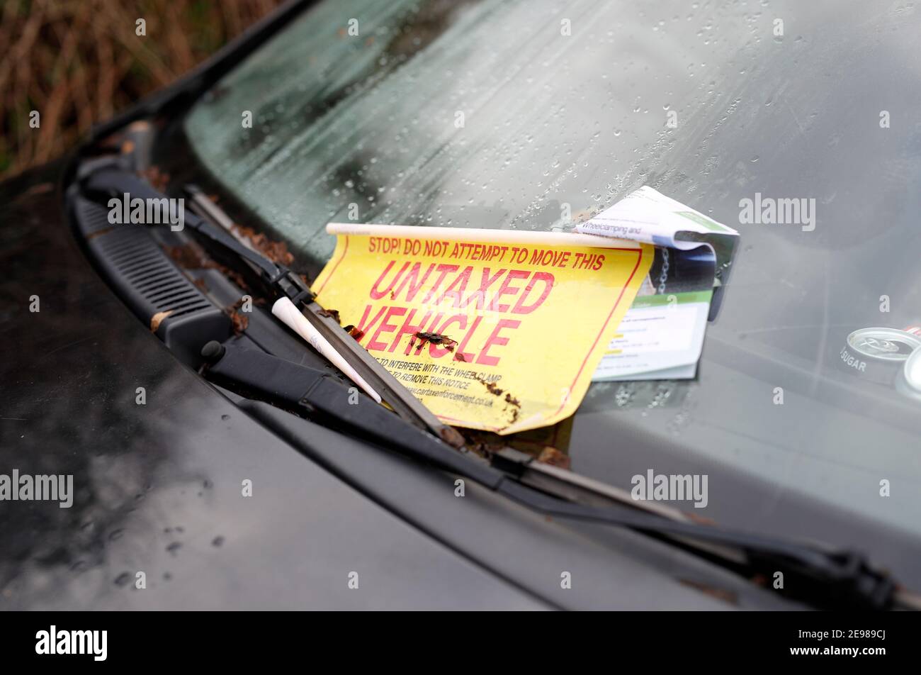 Loughborough, Leicestershire, Großbritannien. 3rd. Februar 2021. Ein Warnaufkleber schält sich von einem Fiat Punto Auto, das durch eine DVLA-Klemme immobilisiert wurde, weil es keine Kfz-Steuer hat. Stockfoto