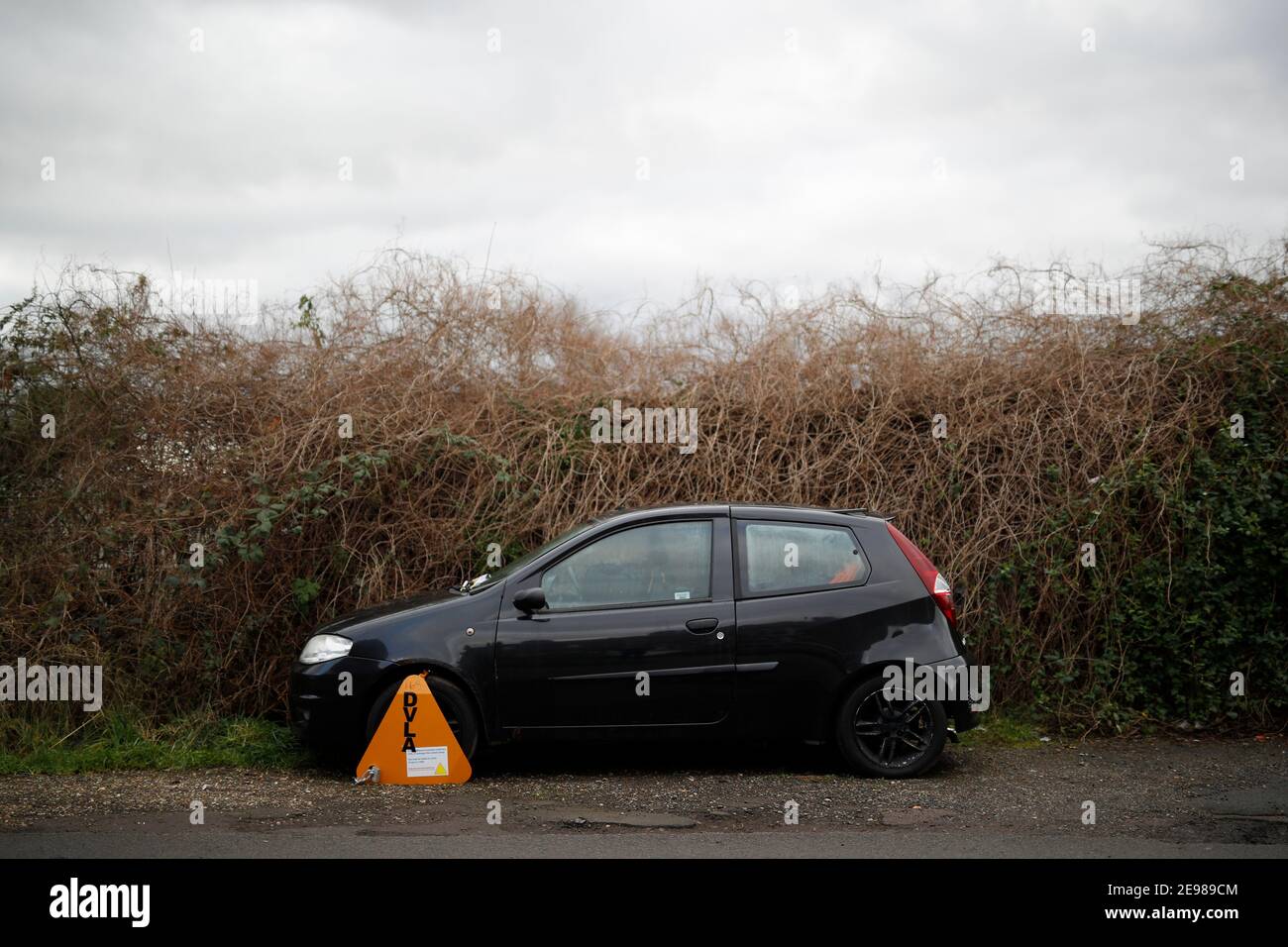 Loughborough, Leicestershire, Großbritannien. 3rd. Februar 2021. Ein Fiat Punto Auto steht durch eine DVLA-Klammer immobilisiert, weil es keine Kfz-Steuer hat. Credit Darren Heftklammer Stockfoto