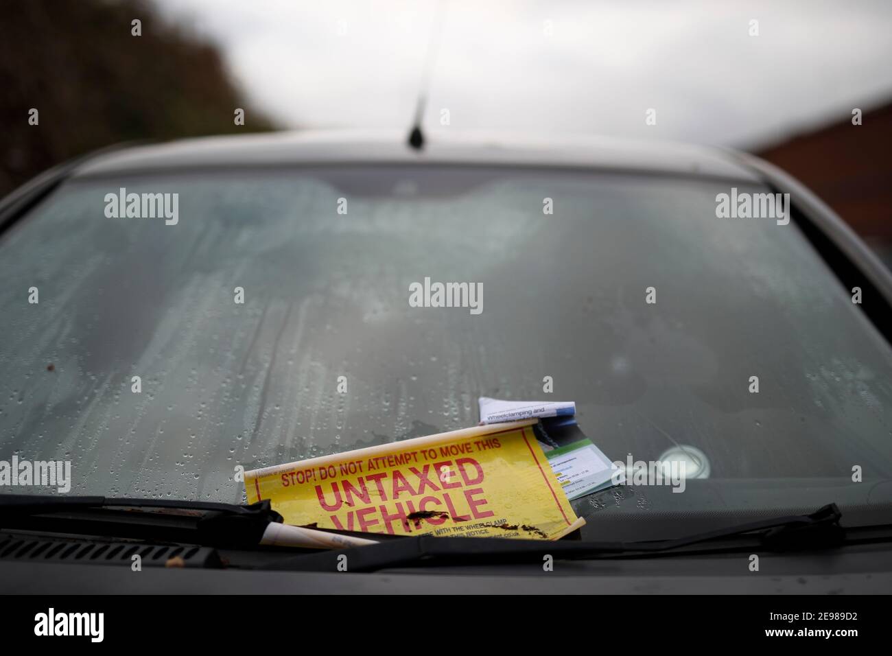 Loughborough, Leicestershire, Großbritannien. 3rd. Februar 2021. Ein Warnaufkleber schält sich von einem Fiat Punto Auto, das durch eine DVLA-Klemme immobilisiert wurde, weil es keine Kfz-Steuer hat. Stockfoto
