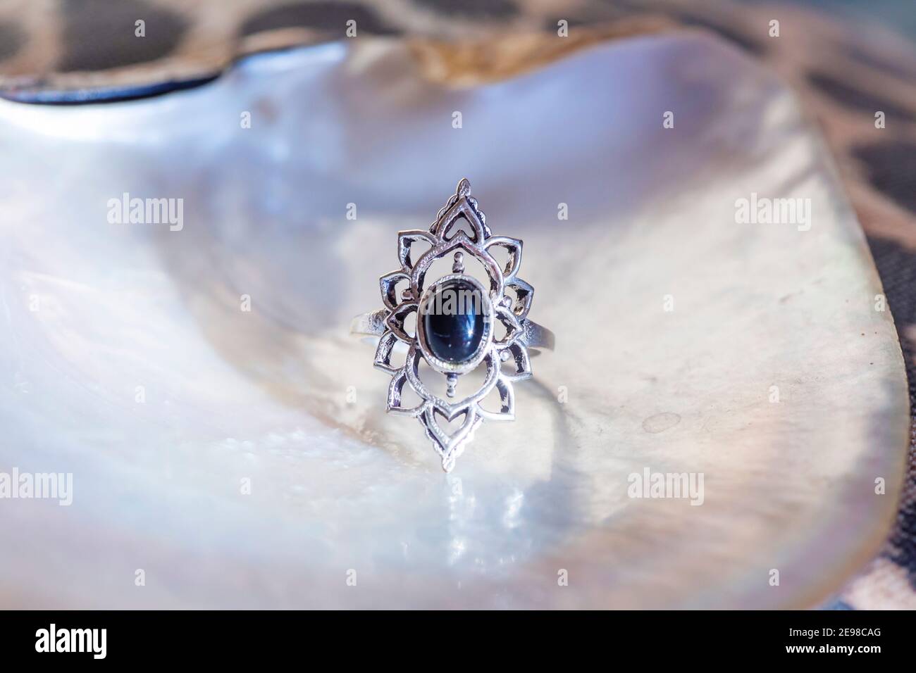Antiker Silberring mit schwarzem Onyx Mineralstein auf Weiß Shell-Hintergrund Stockfoto