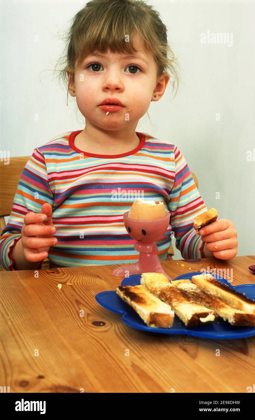 3-jährige Mädchen essen ein gekochtes Ei zum Frühstück Stockfoto