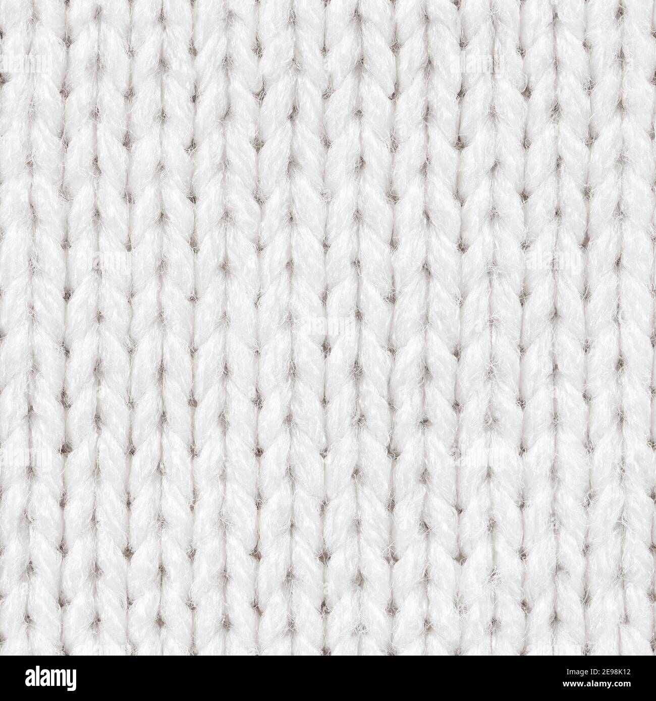 Nahtloses Muster in weißer Strickqualität für randlose Füllung. Strickmaterial wiederholendes Muster für Hintergrund Nahaufnahme. Stockfoto